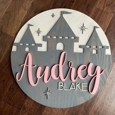 a wooden sign that says,'audrey lake'with a castle in the background