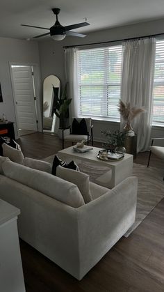 a living room filled with furniture and a flat screen tv mounted to the wall next to a window