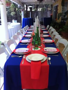 the table is set up with red, white and blue linens for an elegant dinner