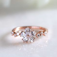 a rose shaped diamond ring on top of a white surface