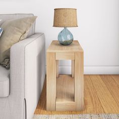 a blue vase sitting on top of a wooden table next to a white couch in a living room