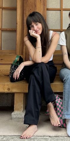 two young women sitting on a wooden bench