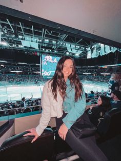 a woman is sitting in the stands at a baseball game