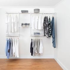 an organized closet with clothes hanging on shelves