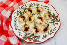 small appetizers are arranged on a white and red plate