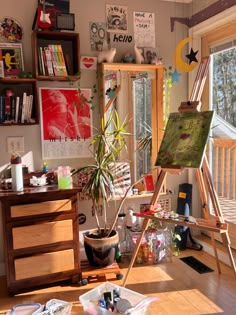 an artist's easel in front of a window filled with art supplies