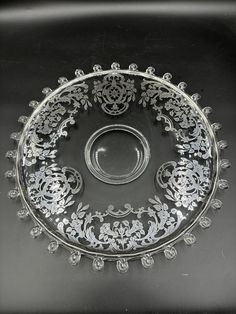 an ornate glass bowl on a black surface