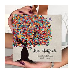 two hands holding up a card with a colorful tree on the front and back cover