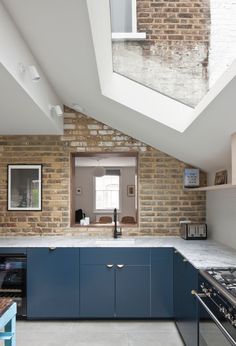 an open kitchen with skylights and blue cabinets