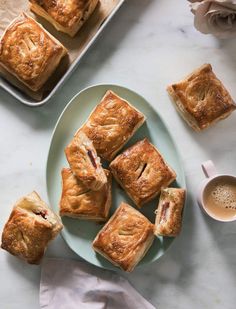 a white plate topped with pastries next to a cup of coffee