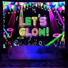 a couch sitting in front of a wall with balloons and streamers on it that says let's glow