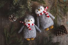 two knitted penguin ornaments hanging from a christmas tree