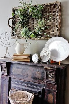 an old fireplace with wicker basket and plates on top