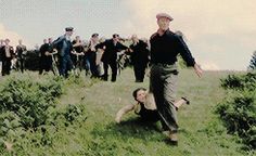 a group of people standing on top of a lush green field next to each other