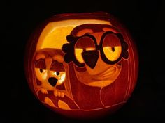 a carved pumpkin with an owl and two dogs on it