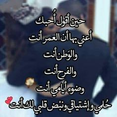 two people hugging each other in front of a mirror with an arabic quote on it