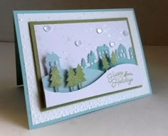 a handmade christmas card with trees and snow on the ground in front of a white background