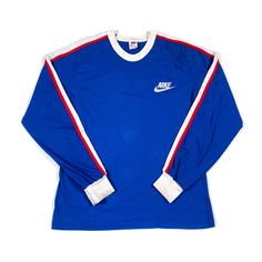 This is a vintage 1970s Nike Sportswear tshirt, it is in excellent condition and labeled as a size medium. Throwback Long Sleeve T-shirt For College, Throwback Long Sleeve T-shirt For Sports Events, Retro Long Sleeve Sports T-shirt, Sportswear Crew Neck Top With Contrast Stripes, Sportswear Top With Contrast Stripes And Crew Neck, Cotton Sportswear Tops With Three Stripes Branding, Sportswear T-shirt With Side Stripes For Streetwear, Blue Sportswear Top With Three Stripes, Blue Retro Sports T-shirt