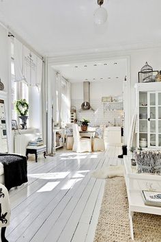 a white living room filled with furniture and decor