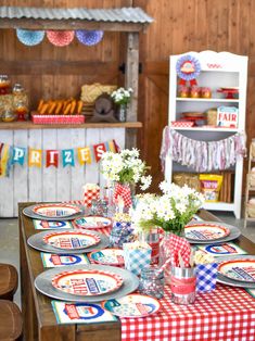 the table is set with plates and flowers