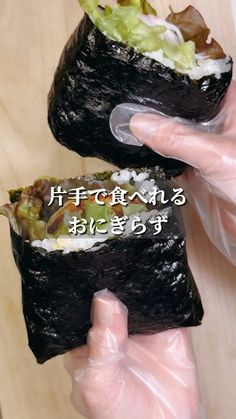 two sushi rolls being held in plastic wrap