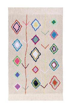 a white rug with multicolored squares and a tree branch in the middle on top of it