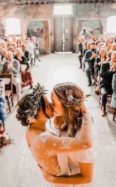 a bride and groom kissing in front of an audience