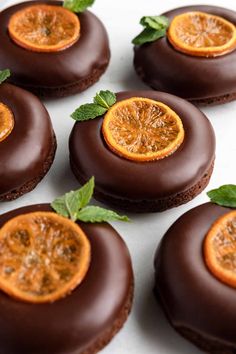 chocolate covered cookies with orange slices and mint leaves