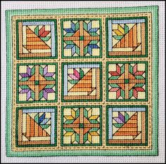 a quilted wall hanging with many different designs on it