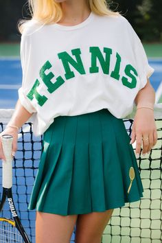 The SINGLES TENNIS TEE is for the tennis pro who loves an oversized tee! Product details: Oversized tee Wide body style Hand wash only Model  is 5’8" and is wearing a size small.  Measurements: SMALL MEDIUM LARGE X-LARGE Length 23" 23" 24" 24" Bust 50” 52" 54" 56" Hips 50” 52”" 54" 56" This is a made-to-order item. All Tennis Style Outfit, Green Athleisure Tennis Top, Green Athleisure Top For Tennis, Athleisure Short Sleeve Tennis T-shirt, Short Sleeve Athleisure Tennis T-shirt, Collegiate Crew Neck Tennis Tops, Spring Tennis Tops With Letter Print, Green Short Sleeve Tennis Top, Sporty Tennis T-shirt With Letter Print