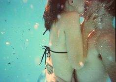 two women are kissing under the water