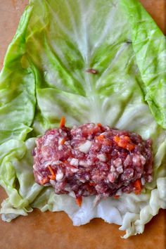 lettuce wraps with meat and carrots on a cutting board next to a knife