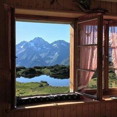 an open window with mountains in the background