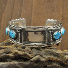 "Southwest sterling silver and turquoise watch bracelet. The front of the cuff is 1\" wide. A watch that is 1 1/16\" from pin to pin, or smaller will fit. Each side has 4 turquoise stones which are just under 7/16\" long. The inside measures 5 7/8\" with a gap of 1 1/16\".  The edges are nicely finished with cut work and stamp work. The inside is stamped Sterling J A. The bracelet is in good condition. Thank you for looking. Please let us know if you have questions. WTCH-864K-BT-7 k *The color y Turquoise Watch Band, Turquoise Watch, Buckle Bunny, Turquoise Men, Cuff Watch, Apple Watch Bands Leather, Turquoise Bracelet Cuff, Watch Bracelet, Sterling Silver Cuff Bracelet