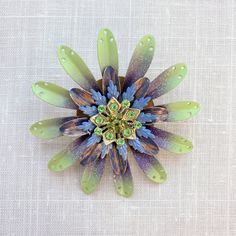 "Eye-catching metal flower brooch in lavender and sage to adorn your suit lapel, sweater, denim jacket or anything else that needs a little something to elevate the look. More is more as we say here at Lenora Dame, so cluster it with other pins from our collection or some of your favorites from your own collection. Great handmade gift for that friend who loves flowers and accessories or treat yourself! Thank you for visiting! ~One-of-a-Kind  ~3.25\" in diameter ~Visit our brooch section for even more fabulous bling and flower brooches! https://etsy.me/3yPMSVB" Spring Brooch Pins As Gifts, Spring Green Brooch Gift, Green Spring Brooches As Gifts, Green Spring Brooches Perfect As A Gift, Green Spring Gift Brooches, Spring Flower Brooches With Flower Decoration, More Is More, Lavender Sage, Metal Flower