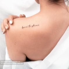 the back of a woman's shoulder with a tattoo saying born to shine on it