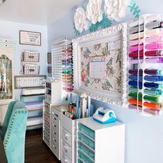 a room with many crafting supplies on the wall and drawers in front of it