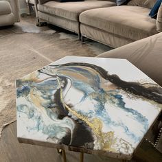 a marble coffee table sitting on top of a hard wood floor in a living room