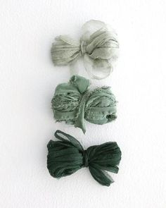 three different types of hair bows on a white surface with one being tied to the side