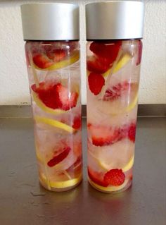 two cups with strawberries and lemon slices in them