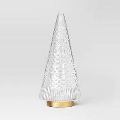 a clear glass christmas tree sitting on top of a metal stand with a gold base