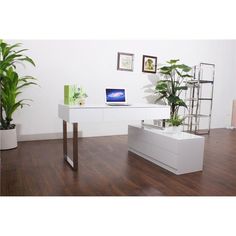 a white desk with a laptop on top of it next to a potted plant