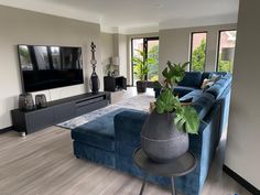 a living room filled with furniture and a large flat screen tv mounted on the wall