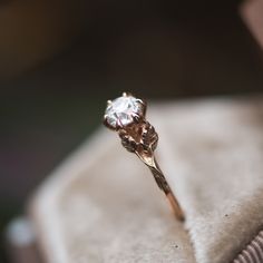 a diamond ring sitting on top of a cushion