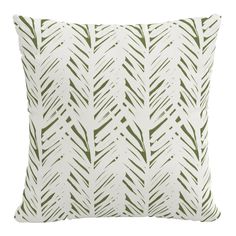 a green and white pillow with an abstract design on the front, featuring small leaves