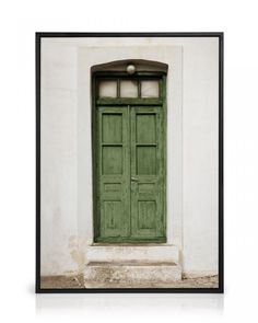 an old green door is in front of a white wall with a black frame on it