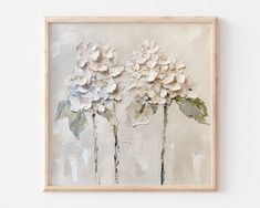 three white flowers on a beige background in a wooden frame, hanging on the wall