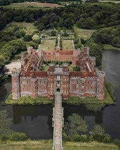 an aerial view of a castle with water in the foreground