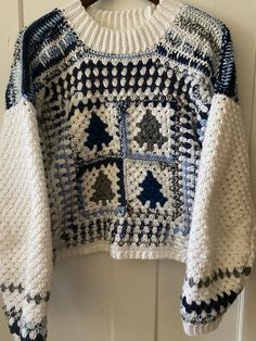 a white and blue sweater hanging on a door