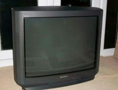 an old television sitting on the floor in front of a window